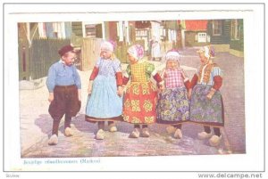 Jeugdige eilandbewoners, Boy and four girls walking hand in hand down the str...