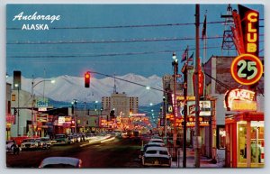 Anchorage Alaska~City St View~Dusk~Neon Signs~Cars~Chugach Mts~1950s Postcard