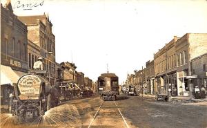 Ames IA Dirt Street Water Truck Trolley Store Fronts RPPC Postcard