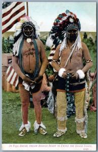 INDIAN BRAVES READY TO ENTER THE GRASS DANCE ANTIQUE POSTCARD US FLAG FULL DRESS