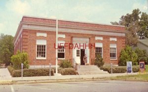 woman walks out front door of POST OFFICE, LOUISVILLE, MS.