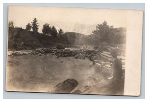 Vintage 1900's RPPC Postcard Man Sitting on a Riverbank Near Log Jam COOL