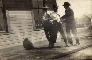 Men Play Acting Roughing Up Fighting a Guy Unusual c1910 Real Photo Postcard