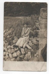 woman in maxi suit and hat sitting in large rocks terrain cabinet card postcard