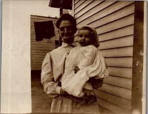 c1910 FARM LADY WITH BABY OUTSIDE HOUSE CLOTHESLINE IN BACK RPPC POSTCARD 38-69