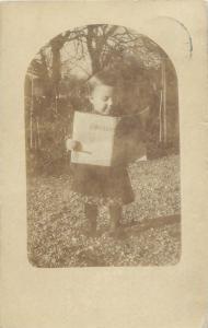 Photo postcard Switzerland dated 1915 little baby girl reading newspaper