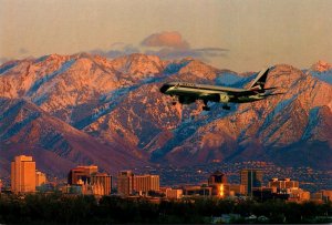 Utah Salt Lake City Delta Jet Landing With Snowcapped Wasatch Mountains In Ba...