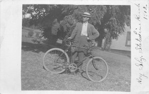 Postcard RPPC C-1919 Man Bicycle cycling Stand line ranch TR24-1579