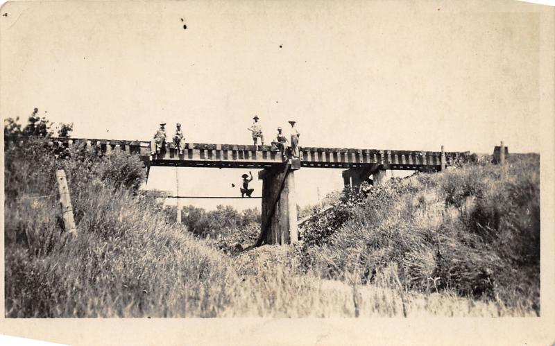 Nebraska~Boys Sitting-Standing on Bridge~One Jumps in Water~c1910 RPPC