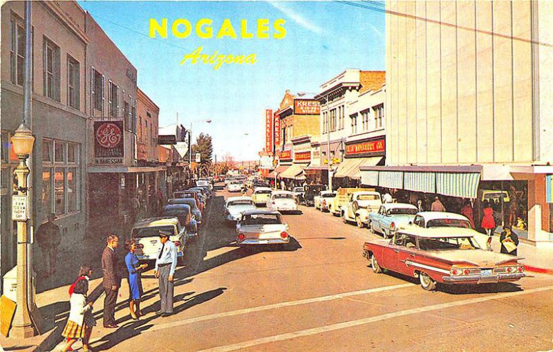 Nogales AZ Street View Store Fronts Policeman Old Cars Postcard