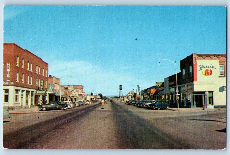 Ashton Idaho Postcard Main Street Looking East Road Buildings Classic Cars c1960