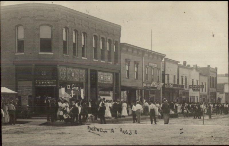 Rockwell IA Busy Street Signs in Store Windows Drug Store Ice Cream RPPC c1910