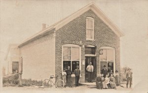 FORT RECOVERY OH~PEOPLE & BICYCLE POSE AT STORFRONT~1909 REAL PHOTO POSTCARD