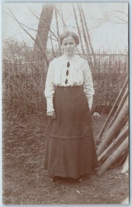 c1910s Cute Woman Outdoors RPPC Fence Winter Dress Fashion Fall Stick Photo A212