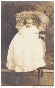 RP; Baby dressed in long white gown, siting in fur-covred high chair, 00-10s