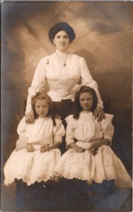 Real Photo Postcard Well Dressed Mother and Two Daughters in Photo Studio