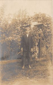 1910s RPPC Real Photo Postcard Boy Standing By Fence Vines