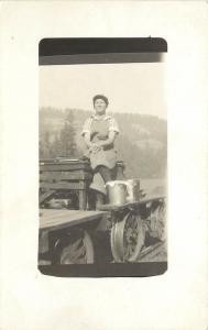 c1910 RPPC Woman Sits on Rail Car with Pails Nellie Coutes at Hotel in WA