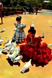 Young Girls In Local Costumes Feeding Pigeons Sevilla Spain