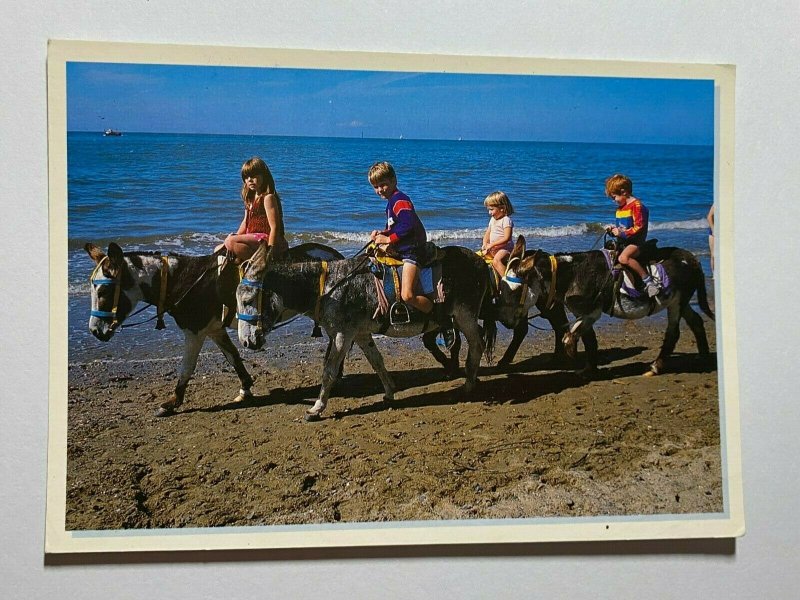 POSTED VINTAGE POSTCARD - CHILDREN RIDING DONKEYS AT SEASIDE (KK1318)