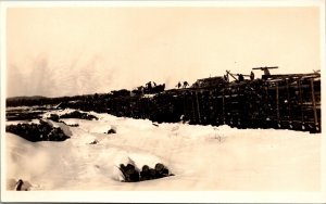 Real Photo Postcard Men Loading/Unloading Logs From Railroad Train in the Snow