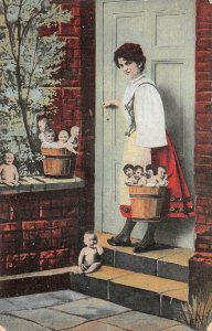 WOMAN WITH BASKETS OF BABIES BABY FANTASY POSTCARD (c. 1910)