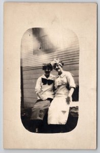 RPPC Two Women With Bows Embracing On Bench Real Photo Postcard Q27