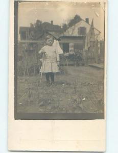 Pre-1918 rppc CHILD HOLDING A CHILD SIZED SHOVEL IN THE GARDEN HM0199