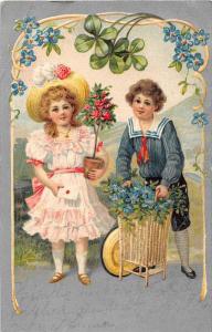 Little Girl and Little boy with baskets of flowers and under 4 leaf clover