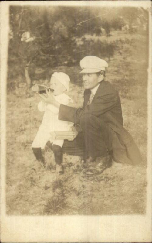 Unusual Dad w/ Son Helping Him w/ Bottle - Box in Hand c1910 RPPC