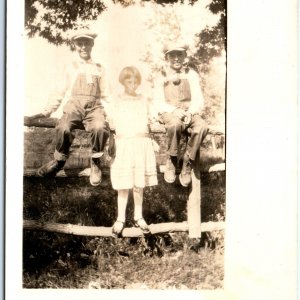 c1910s Young Boys Overalls & Newsboy Hat RPPC Paper Smiling Boy Photo Fence A156