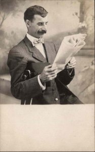 Man in Studio Big Nose Reading Newspaper c1905 Real Photo Postcard