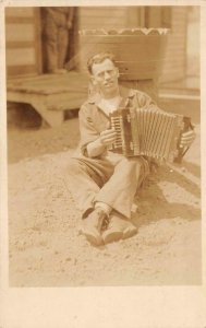 RPPC,  MAN Sitting On Ground PLAYING ACCORDIAN   ca1920's Real Photo Postcard
