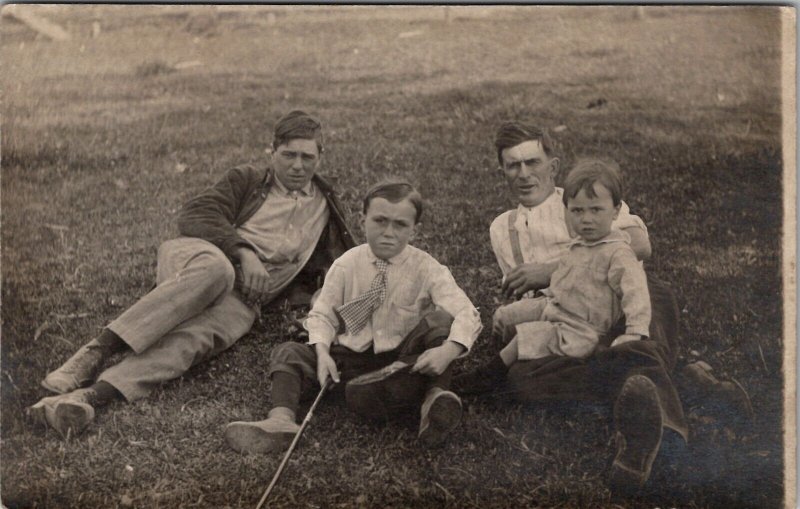 RPPC Attractive Young Men in Grass with Children c1910 Real Photo Postcard Y13