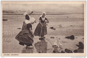 ZEELAND, Netherlands; Walcheren, Dutch Girls playing with toy sailboat, 00-10s