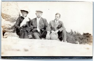 Family by boulder - mother, father, son - rppc AZO  1904-1918