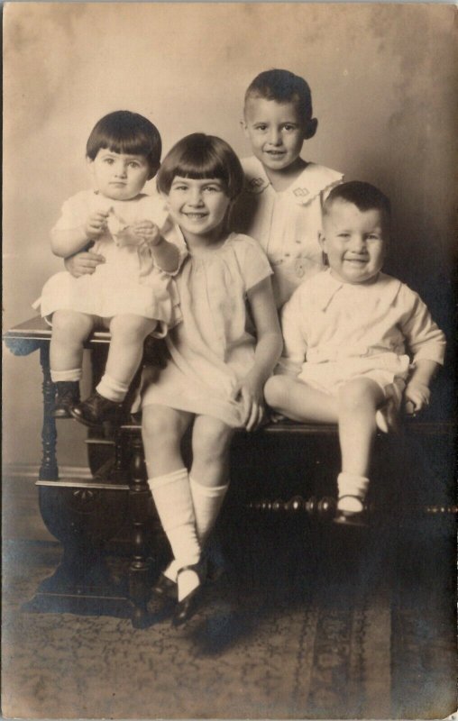 RPPC Sweet Children Girls Pixie Haircuts Sitting on Table Postcard U9