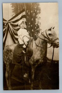 SMALL GIRL POSING ON HORSE PATRIOTIC BACKGROUND ANTIQUE REAL PHOTO POSTCARD RPPC