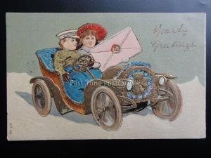 Greeting: Embossed HEARTY GREETINGS Boy & Girl in Car, Four Leaved Clover c1907