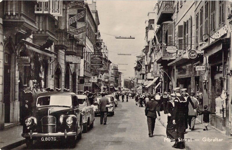 Main Street, Gibralter Real Photo Postcard. Old Cars. Sailors. Storefronts Signs 