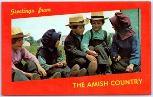 Amish Children sitting in grass - Greetings, From The Amish Country - PA