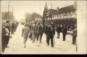 Parade Street Scene Man w/ American Flag Unidentified c1910 RPPC Postcard