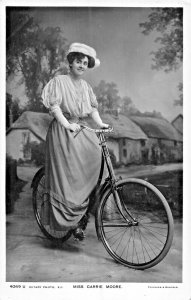 MISS CARRIE MOORE RIDING BICYCLE-BRITISH ACTRESS~ROTARY REAL PHOTO POSTCARD