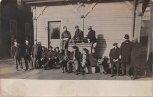 LARGE GROUP OF MEN POSING IN FRONT OF BUILDING~REAL PHOTO POSTCARD 1900s