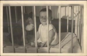 Baby in Crib w/ Stuffed Dog Toy Real Photo Postcard 1933