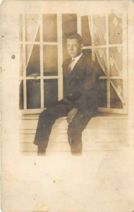 1910s RPPC Real Photo Postcard Young Man Sitting In Window Ledge