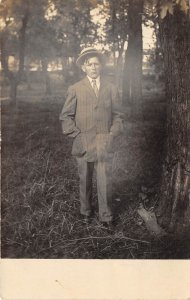 c1910 RPPC Real Photo Postcard Boy In Striped Suit Straw Hat Standing Trees