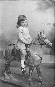 Little girl on toy horse Child, People Photo Writing on back 