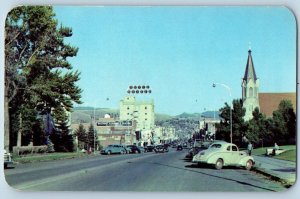 Bozeman Montana MT Postcard Entering Bozeman Car Lined Street Mountain Scene