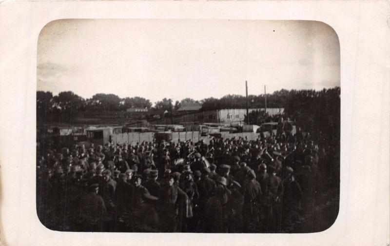 LARGE NUMBER OF GERMAN? MILITARY OUTSIDE OF FENCED AREA REAL PHOTO POSTCARD 1919